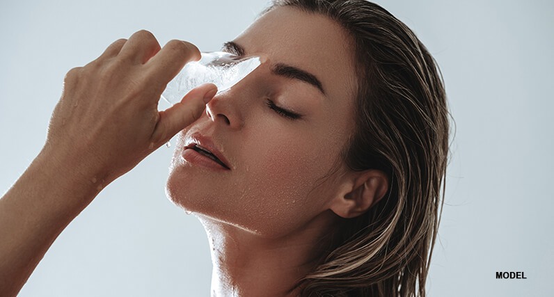 woman model rubbing ice on face
