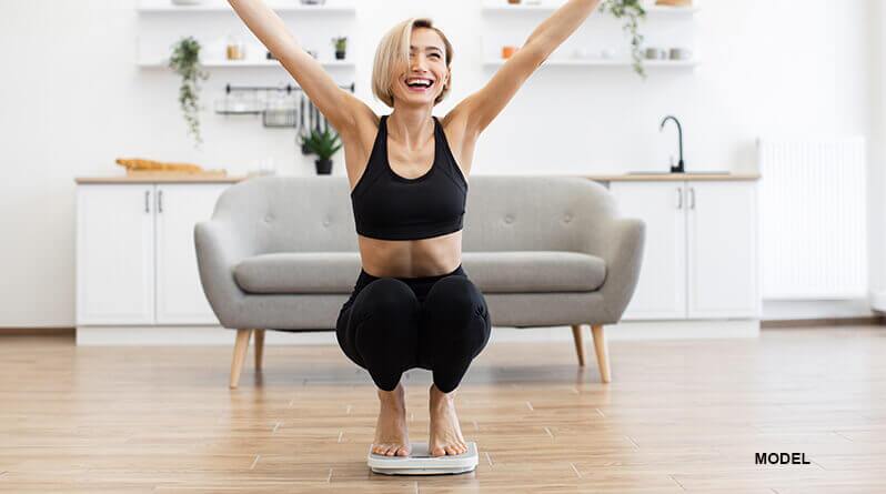 woman standing on scale excited over weight loss