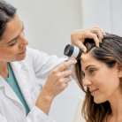 thumbnail dermatologist examining the scalp of a female patient for skin cancer