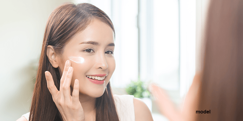 woman applying milky toner to cheeks and face