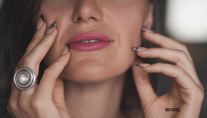 close up of woman touching her jawline