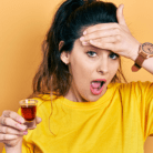 woman drinking alcohol with shocked face