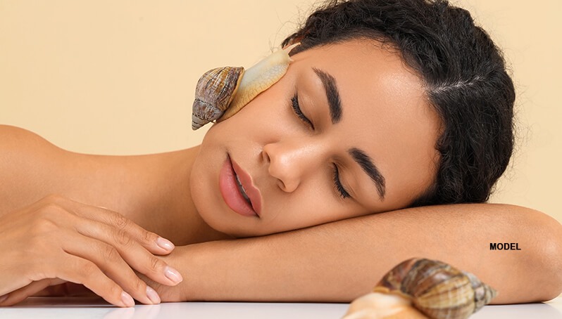 woman with snail crawling on face