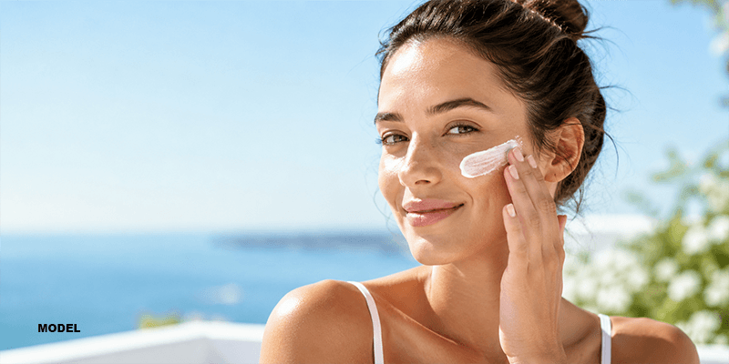 happy woman model applying sunscreen to cheeks